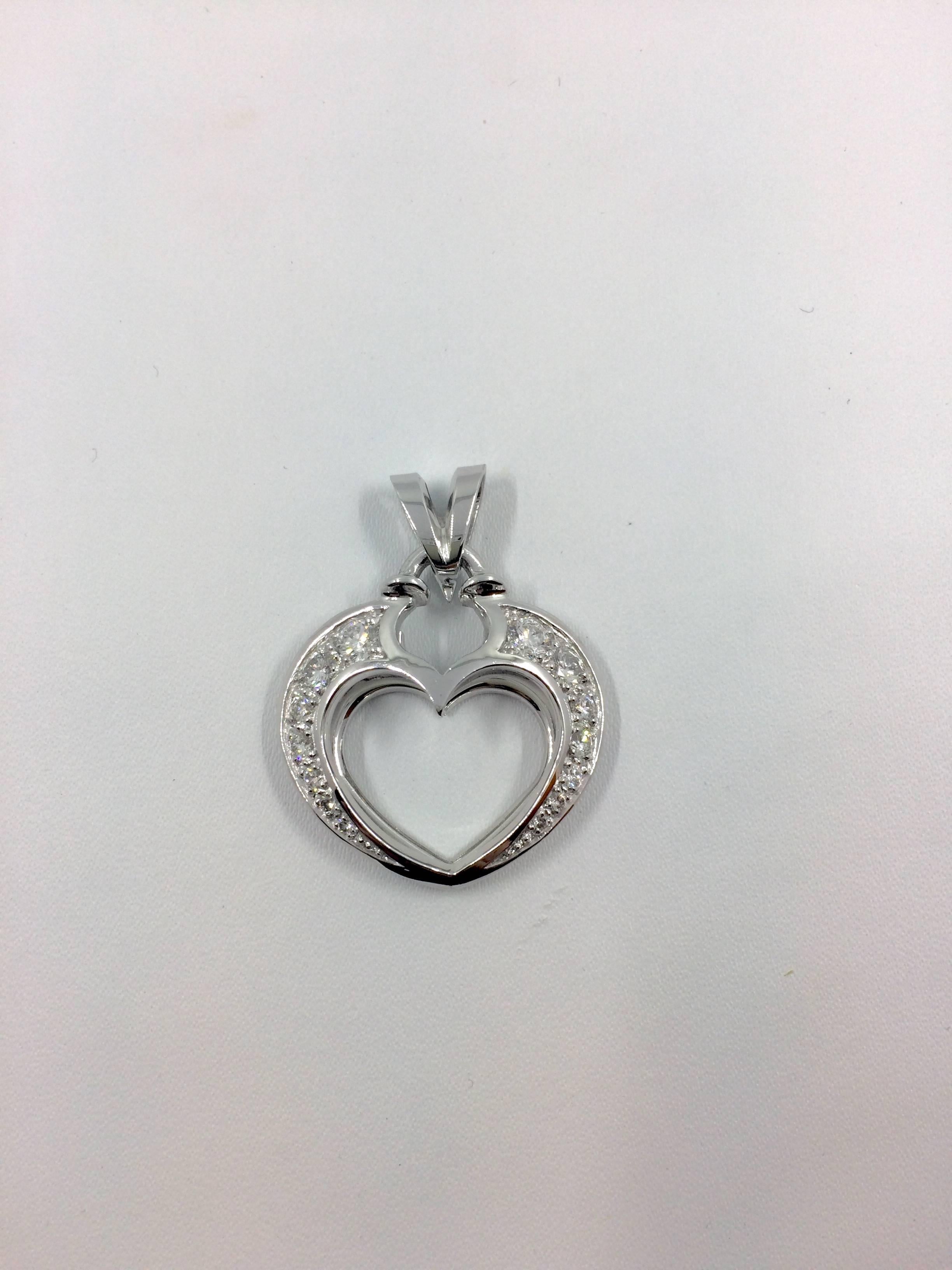 A white gold open heart pendant set with 14 brilliant cut diamonds. 
The pendant is an unique creation entirely handmade.
Total Diamonds Weight: 1.04 carat.
Diamonds Quality: E - F / VVS.
Net Weight: 10.06 grams.