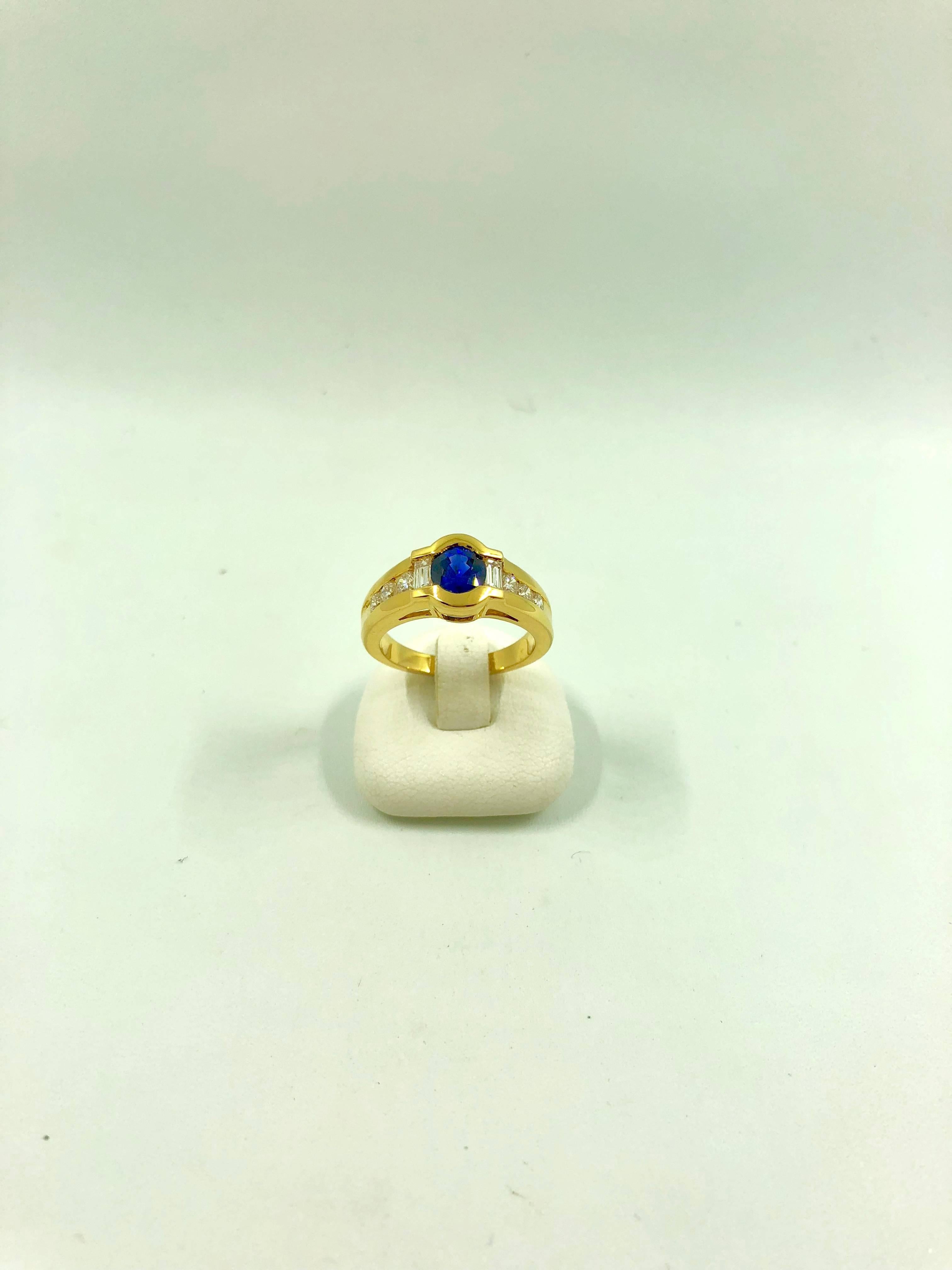 A yellow gold ring set in the middle with a blue sapphire surrounded by a baguette cut diamond and three brilliant cut diamond on each side.
Total Diamond Weight: 0.62 carat
Sapphire Weight: 1.09 carat
Net Weight: 6.60 grams
Finger Size: 6.5 can be