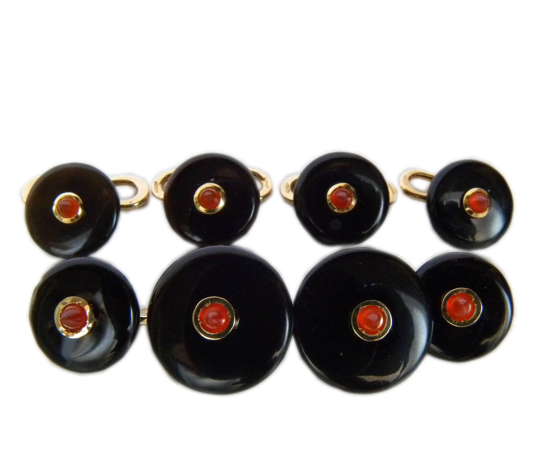 Smart, chic yet timeless 4 stud and cufflinks set combining the vivid red of carnelian cabochon with elegant hand inlaid black round onyx disks, all set in precious 18kt yellow gold.
In our smart black box and pouch.