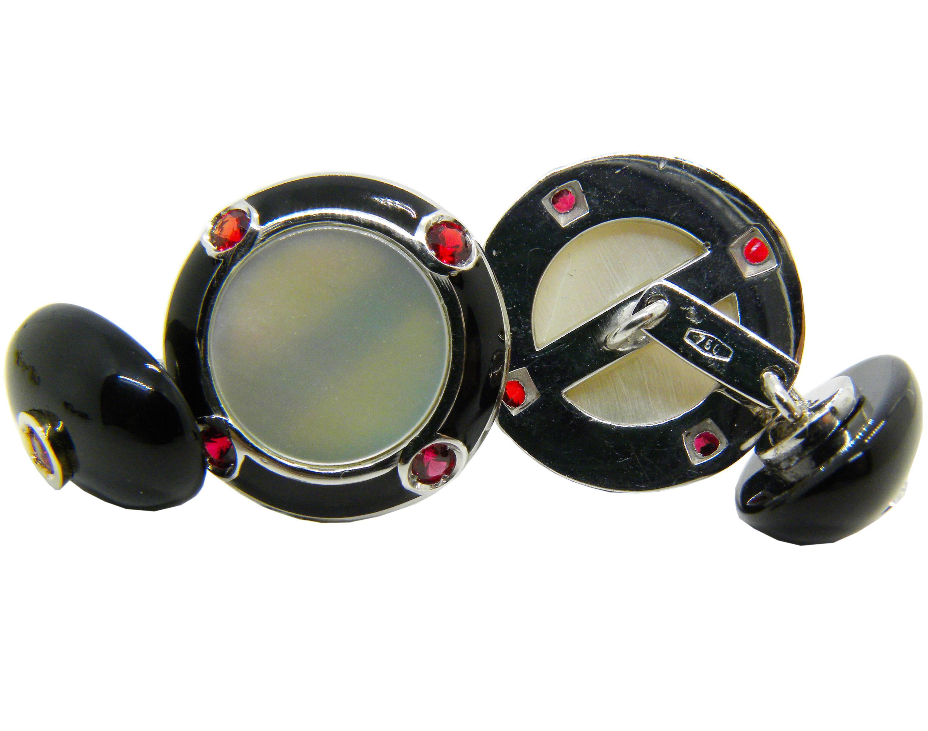 A very chic, Art Déco style, pair of cufflinks featuring a round hand enameled mother-of-pearl color disc surrounded by four rubies(0,68 Carat) and black hand enamel. The back is a ruby in an onyx oval cabochon setting, 18Carat White Gold.
In our