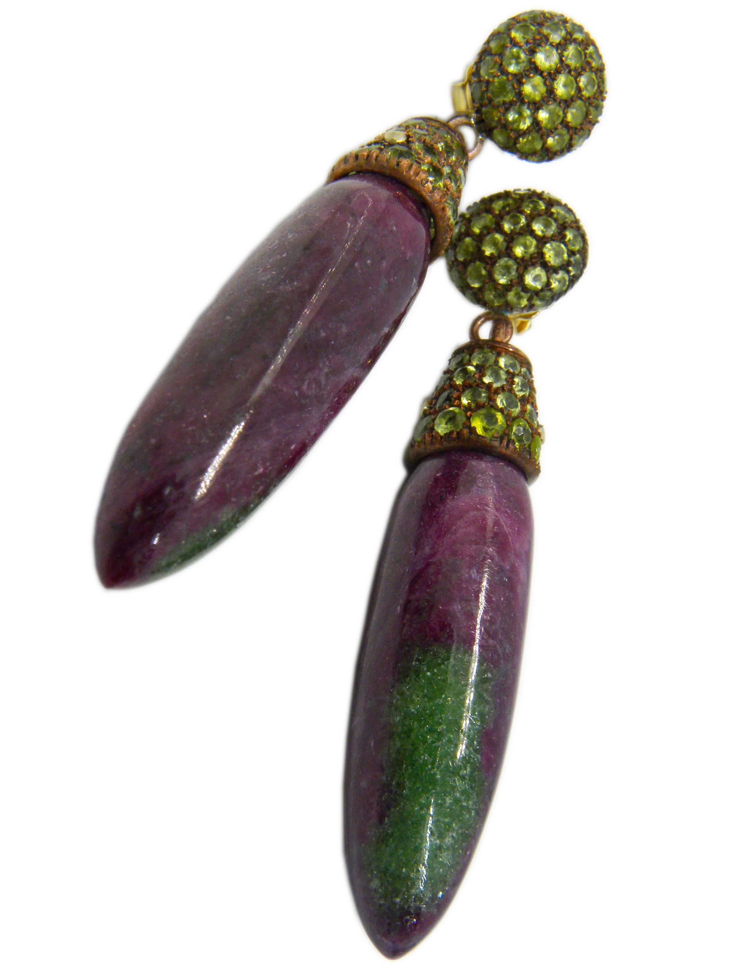 One-of-a-kind 160 Carat Natural Ruby, 7.60 Carat Peridot Oxidized Copper and 18Carat Yellow Gold Setting.
The two ruby drops show some zoisite green spots  typical of this natural stone.