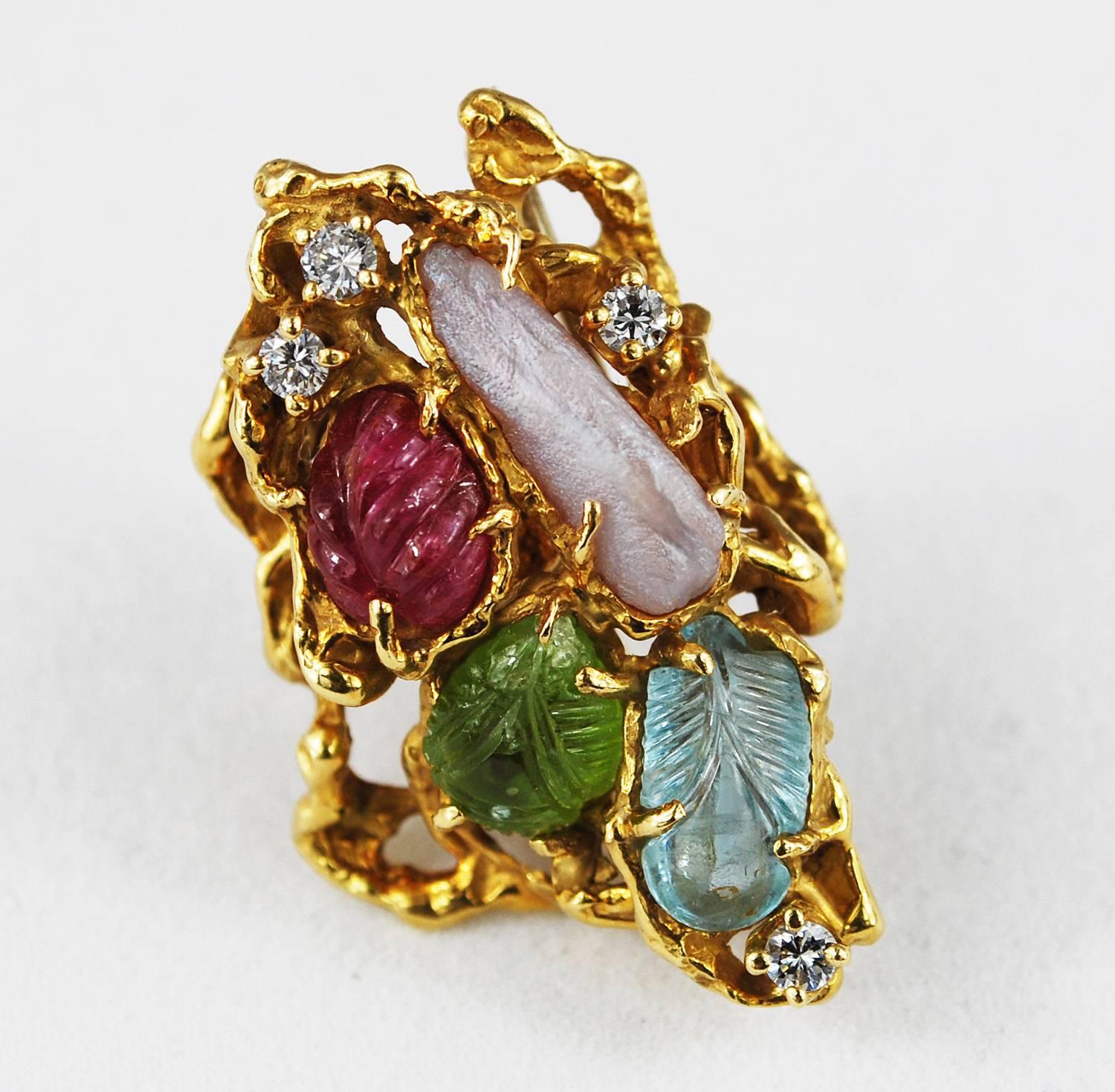 A unique convertible pendant/ brooch with carved ruby, aquamarine, peridot, and pearl and diamonds set in 18K gold made by mid century jewelry designer Arthur King.
Pendant is made in freeform design and has beautiful mix of colors and texture -