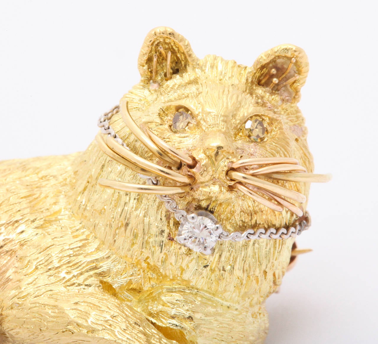 18k yellow gold cat brooch which can also be used as a pendant. This charming  and regal looking feline has yellow diamond eyes and a diamond on his collar. The piece is quite charming.