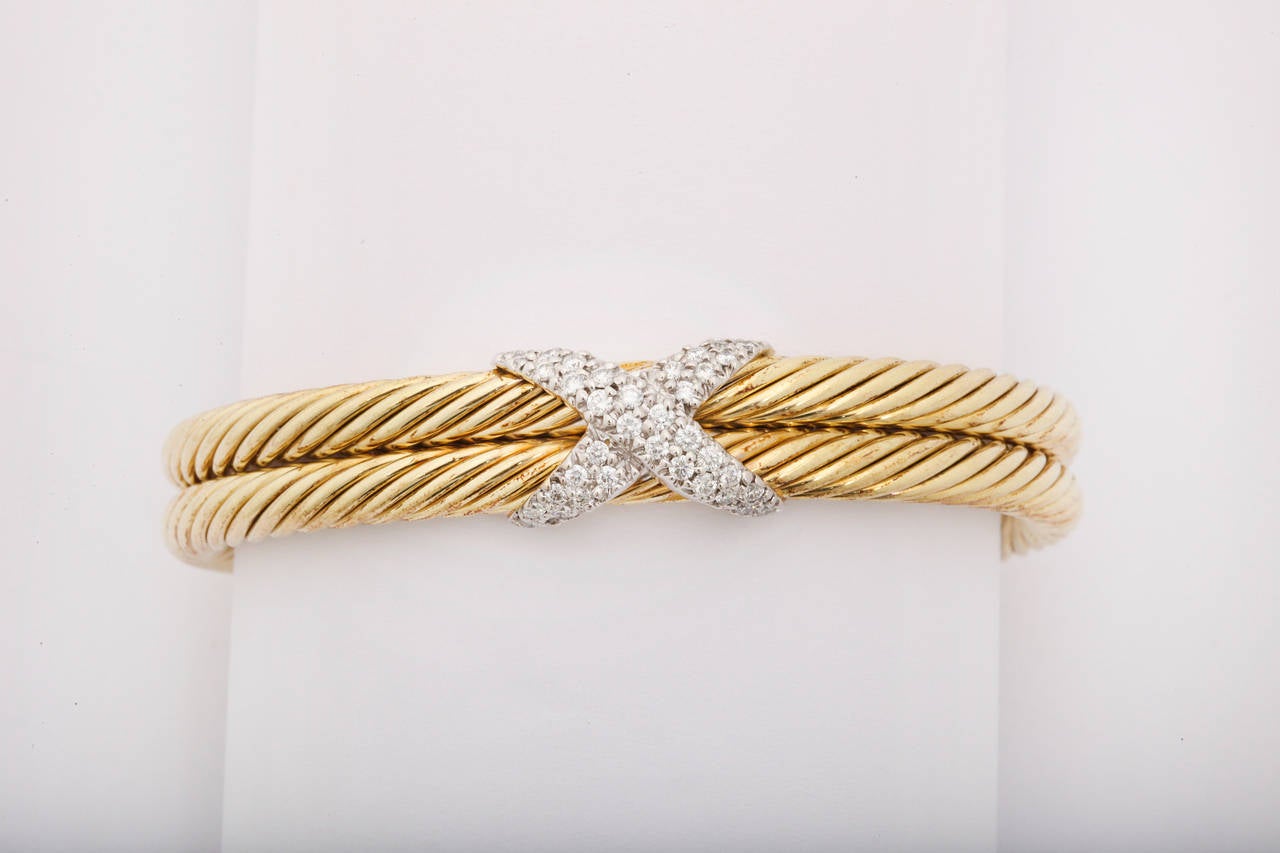 David Yurman two row cable bracelet in 14k yellow gold with a diamond X set in 14k yellow gold. 

Diamond weight approx .70 carat
Width of bracelet 15mm.
Rear gap opening 1