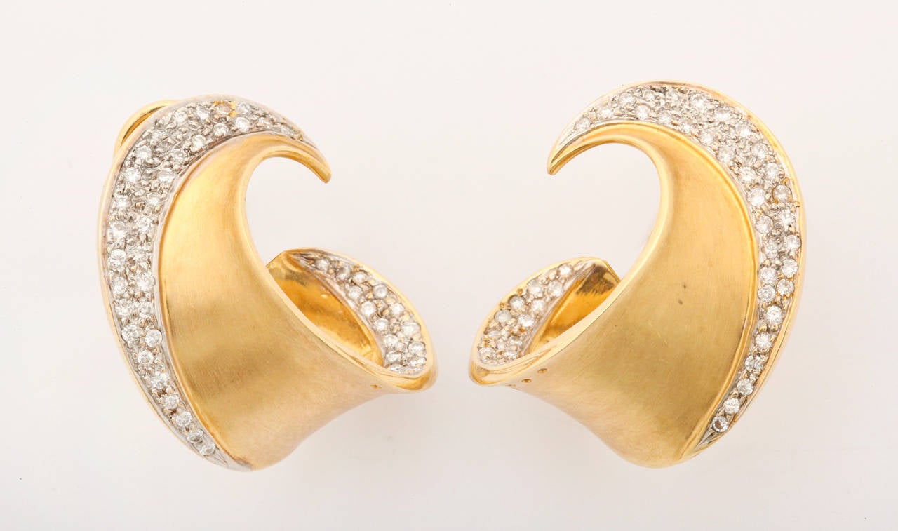 DIamond and 18k gold earrings from the 1980s in a swirl design. A nice feature of these earrings is that the diamonds are on both the outer and inner side of the swirl giving depth to the piece. Most comfortable to wear the back has both an omega