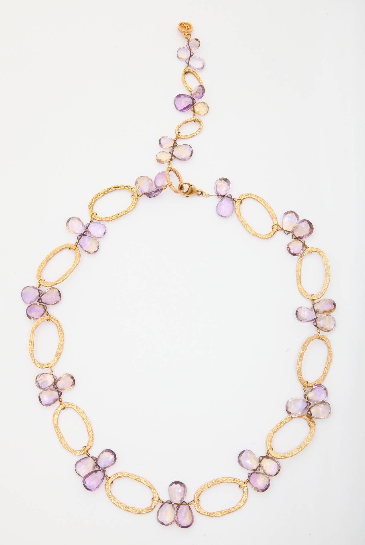 Dominique Cohen 18k gold and  briolette cut amethyst necklace. The necklace is comprised of textured oval loops with clusters of three briolette cut amethysts between each loop. Total length of the necklace is 21