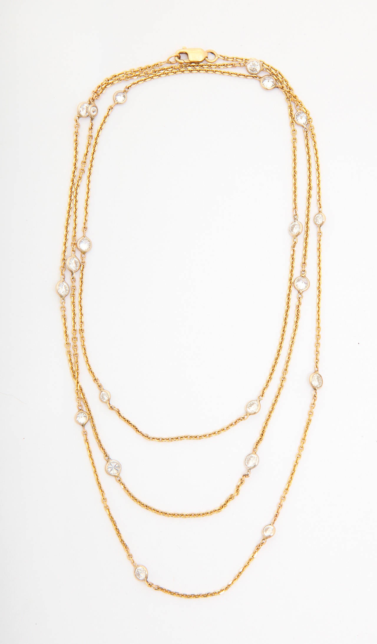 Diamonds by the yard long chain necklace in yellow gold. TOtal weight of the diamonds is approx. 2.5 cts. Of particular interest is that the stones are in various sizes, from 5 to 20 points each. Each stone is hand wrapped by the jeweler in a bezel