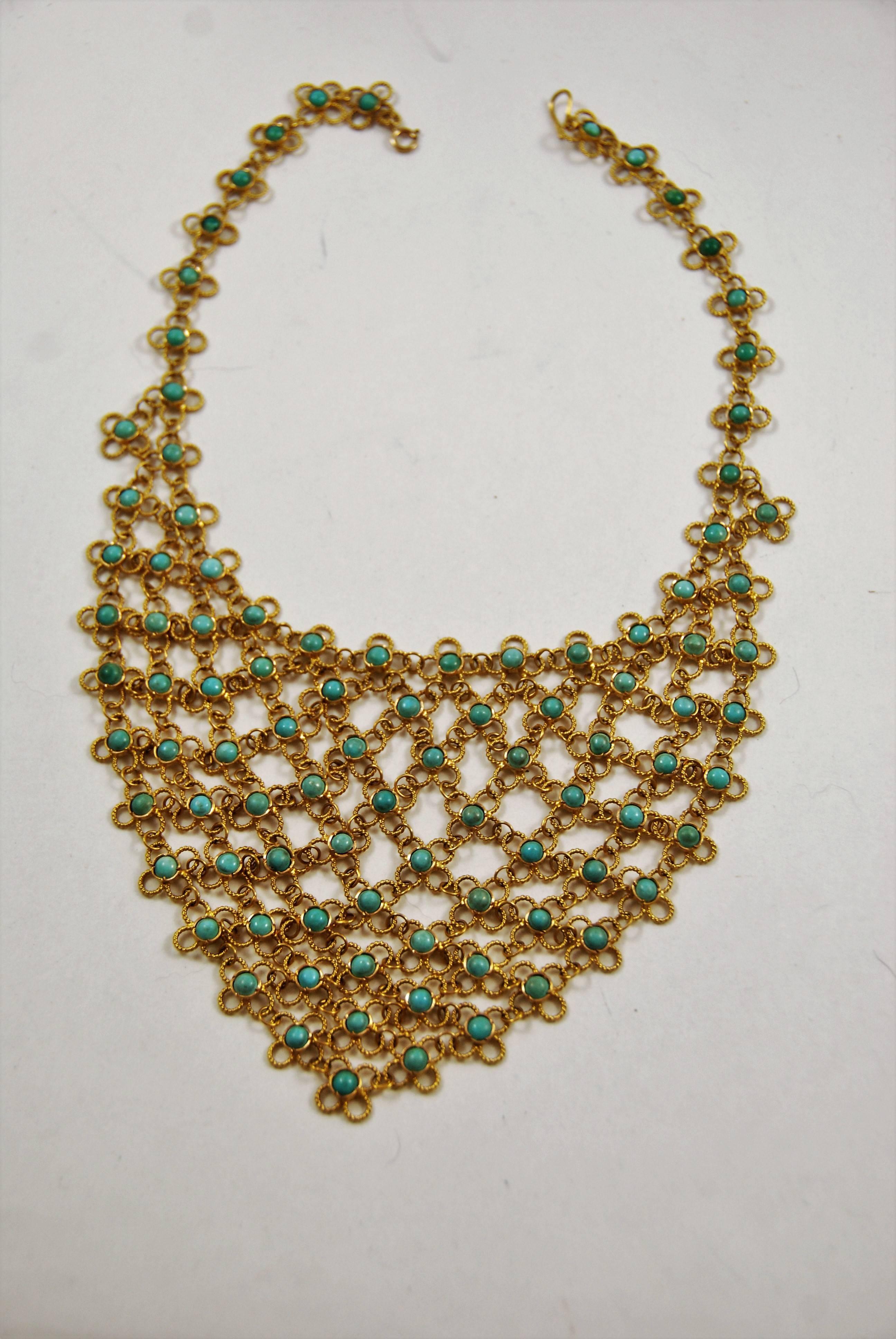 Turquoise and 14k gold bib necklace. Each piece us joined to the othes via a ring making the necklace very flexible. The gold on each piece is in a twisted rope design. The center triangle measures about 6