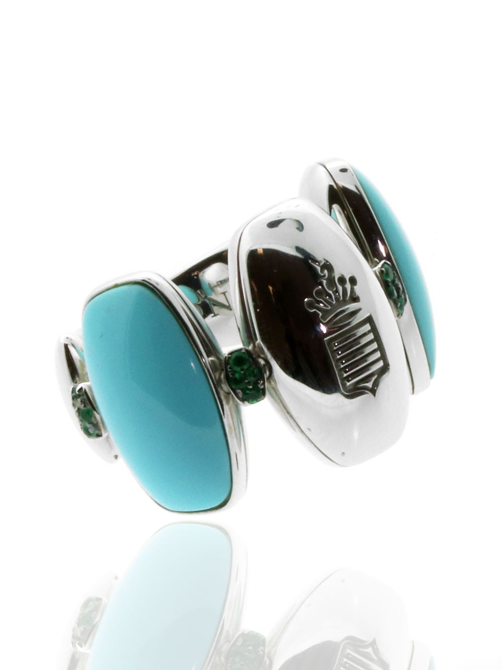 Verdant Emeralds and vibrant Turquoise alternate across this 18k White Gold Ring by De Grisogono, offering one of the jewelry world’s most rare and coveted combinations. There are a total of 16 Round Emeralds (comprising .10ct) and 3 Cabochon