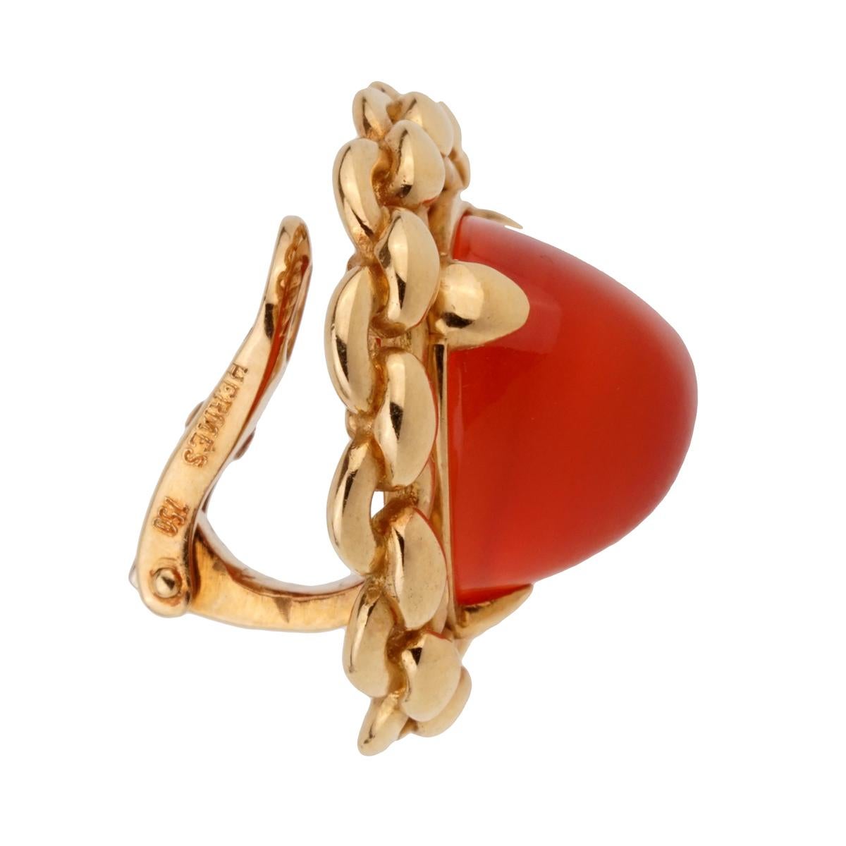 A chic pair of Hermes earrings circa 1980's featuring 2 trillion sugarloaf Carnelian gemstones set in 18k yellow gold. The earrings measure .94