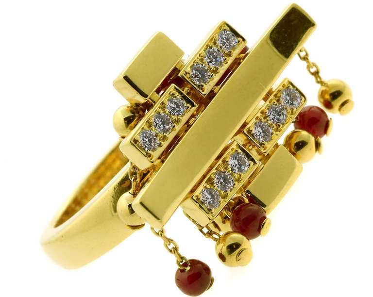 An extremely rare authentic Cartier "Le Baiser du Dragon" cocktail ring features dangling rubies and the finest Cartier round brilliant cut diamonds in 18k yellow gold.

Size: US 6  / EU 52
Dimensions: 1.00″ inch wide by .66″ Inches