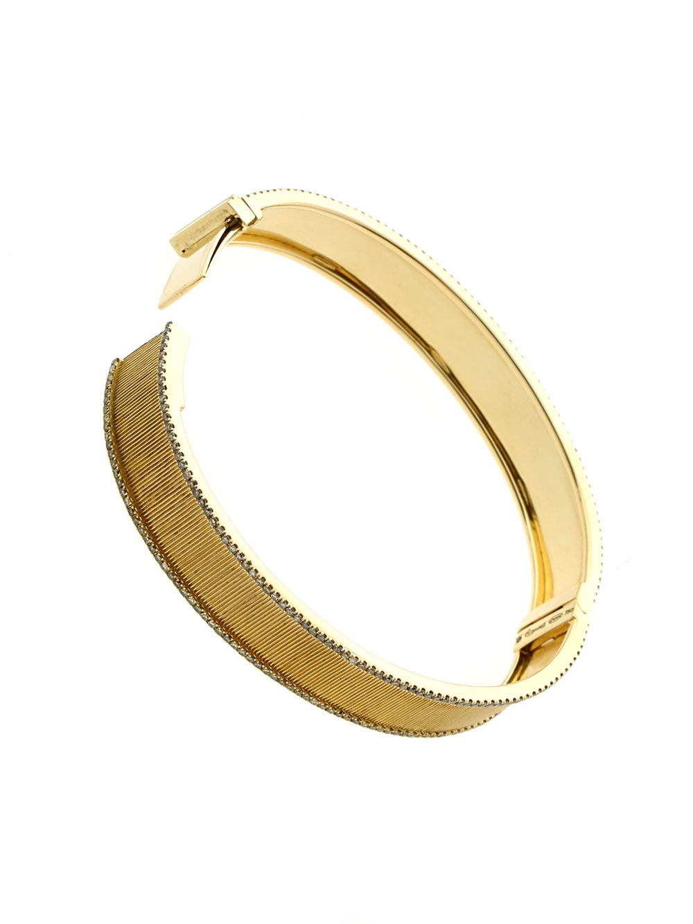 A hand engraved bangle bracelet created in 18k yellow gold featuring 1.5ct of round brilliant cut brown diamonds with a total weight of 36.5 grams.

The bangle measures 11mm wide and will fit a wrist up to 6