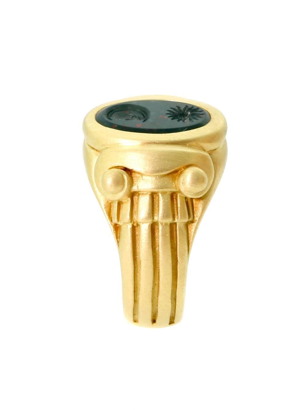 Featuring an alluring Sun and Moon motif carved into Bloodstone and set into the crown of this 18k Yellow Gold Ring from Barry Kieselstein, this is a piece with much to admire. The Yellow Gold design of the band is undoubtedly inspired by ancient