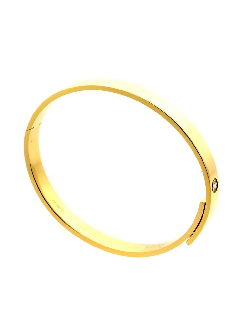 A chic 18k yellow gold Cartier diamond bangle bracelet from the late 90's, set with a .10ct round brilliant cut diamond.

Weight: 41.3 Grams
Length: 7.08