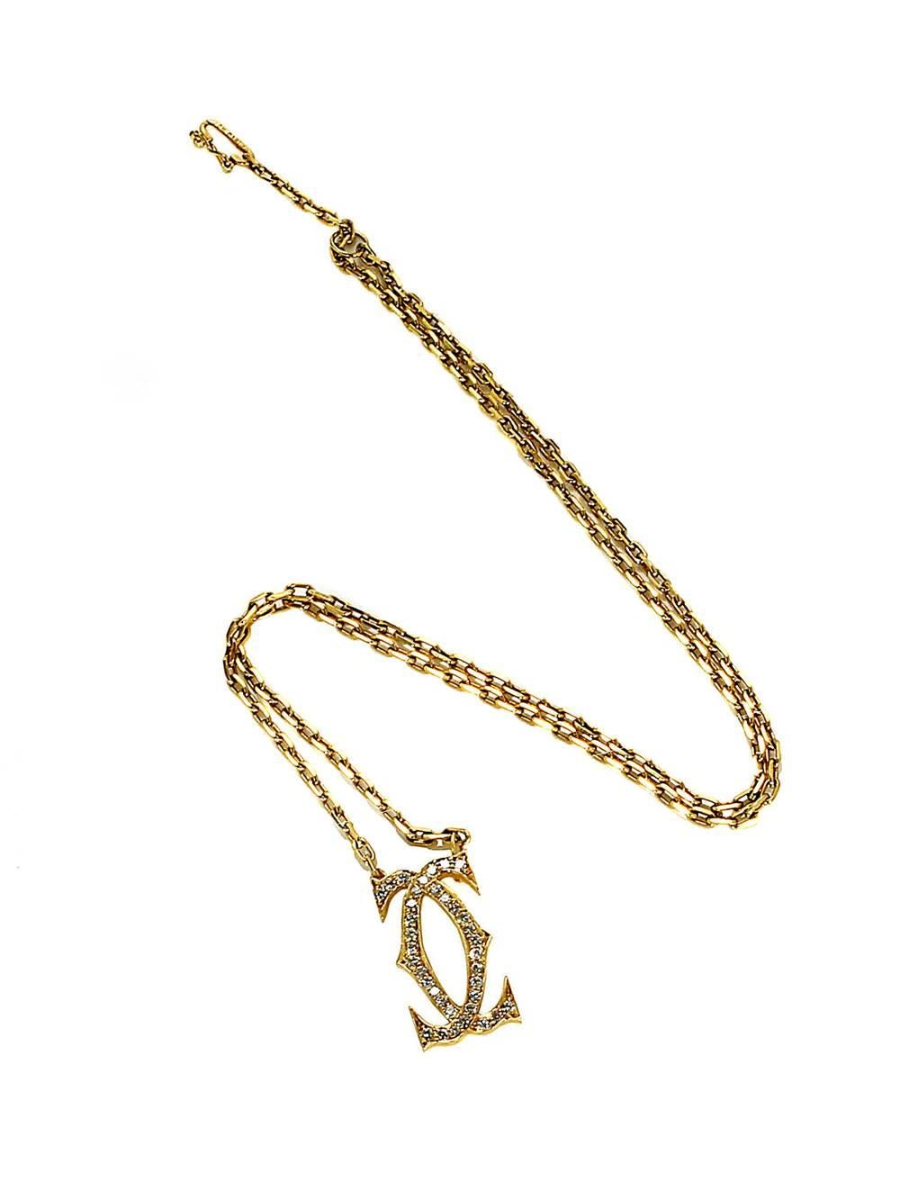 This Cartier Double C necklace from Cartier is a must for the vintage collector! Crafted from fine 18k Yellow Gold and featuring dozens of Round Brilliant Cut Diamonds embedded upon the outward surface of both letter Cs, this necklace is as
