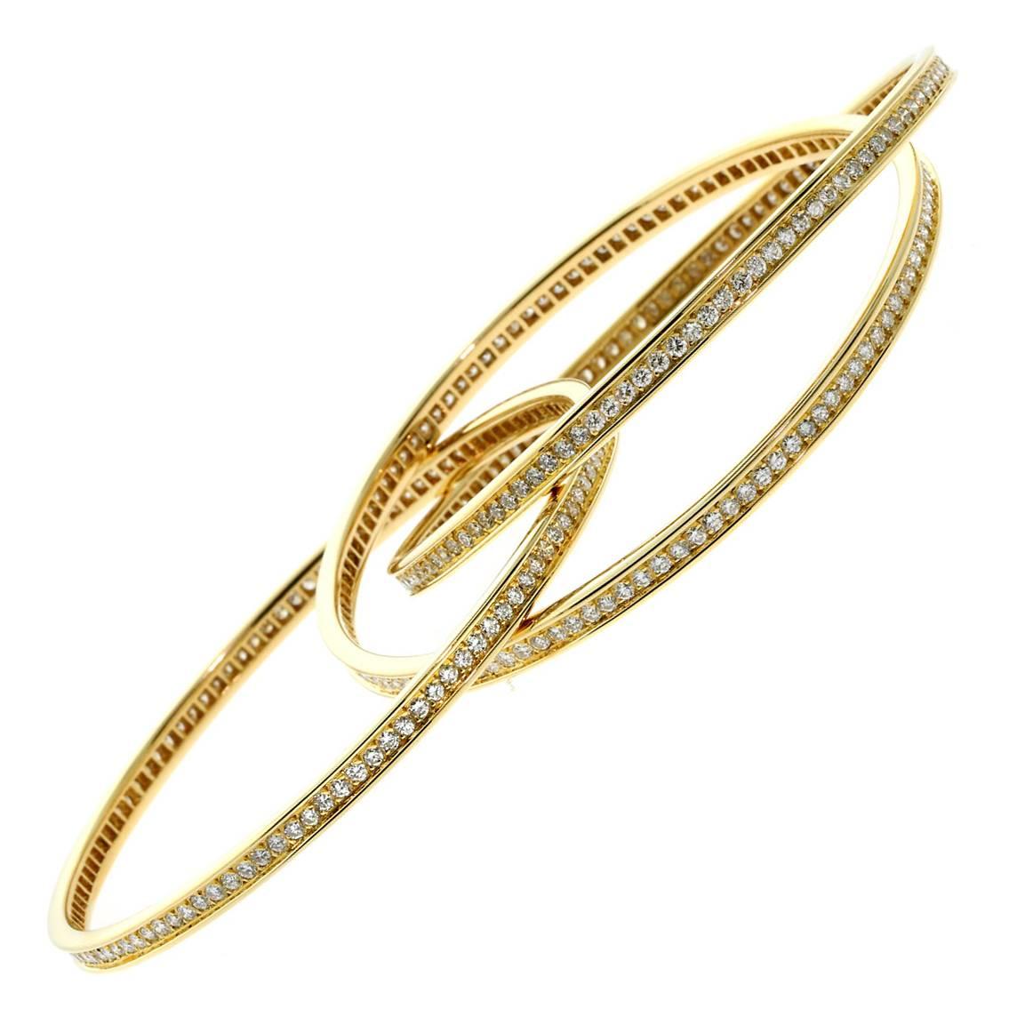A magnificent Cartier "Trinity" bangle, 6.45ct of round brilliant cut diamonds grace the full length of each of these 18k Yellow Gold Trinity Bangles.

Cartier Retail Price: $54,000 + Tax