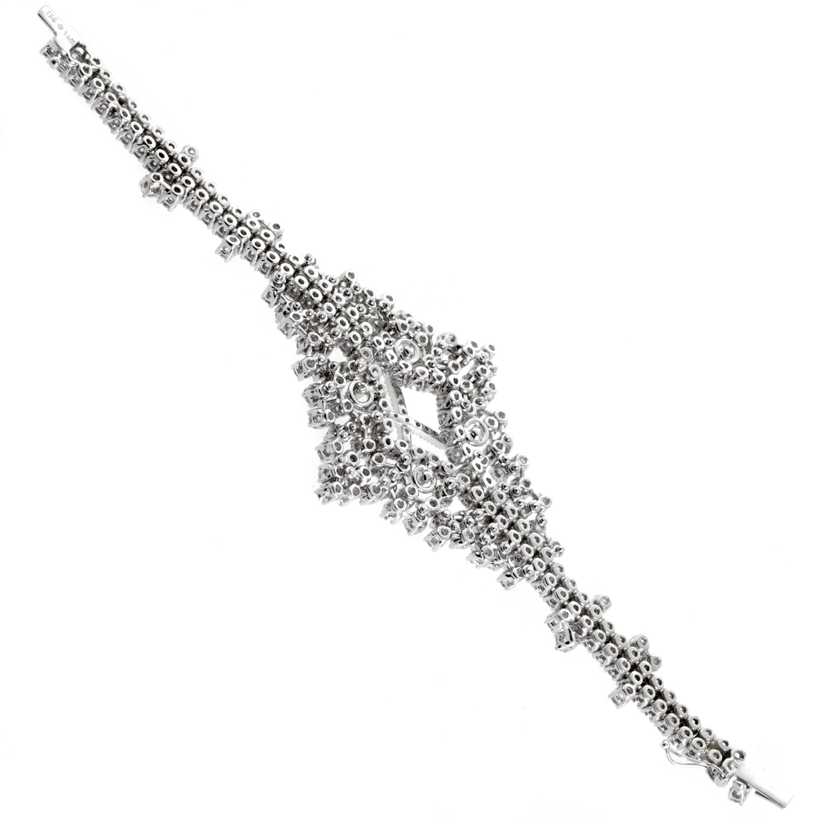 A fabulous hand made 18k white gold diamond bracelet set with appx 14.4cts of round brilliant shiny perfect cut diamonds (Vs-Si1) quality hand set in 18k white gold. The bracelet measures 1.65" at the widest point and 5.90" in length.