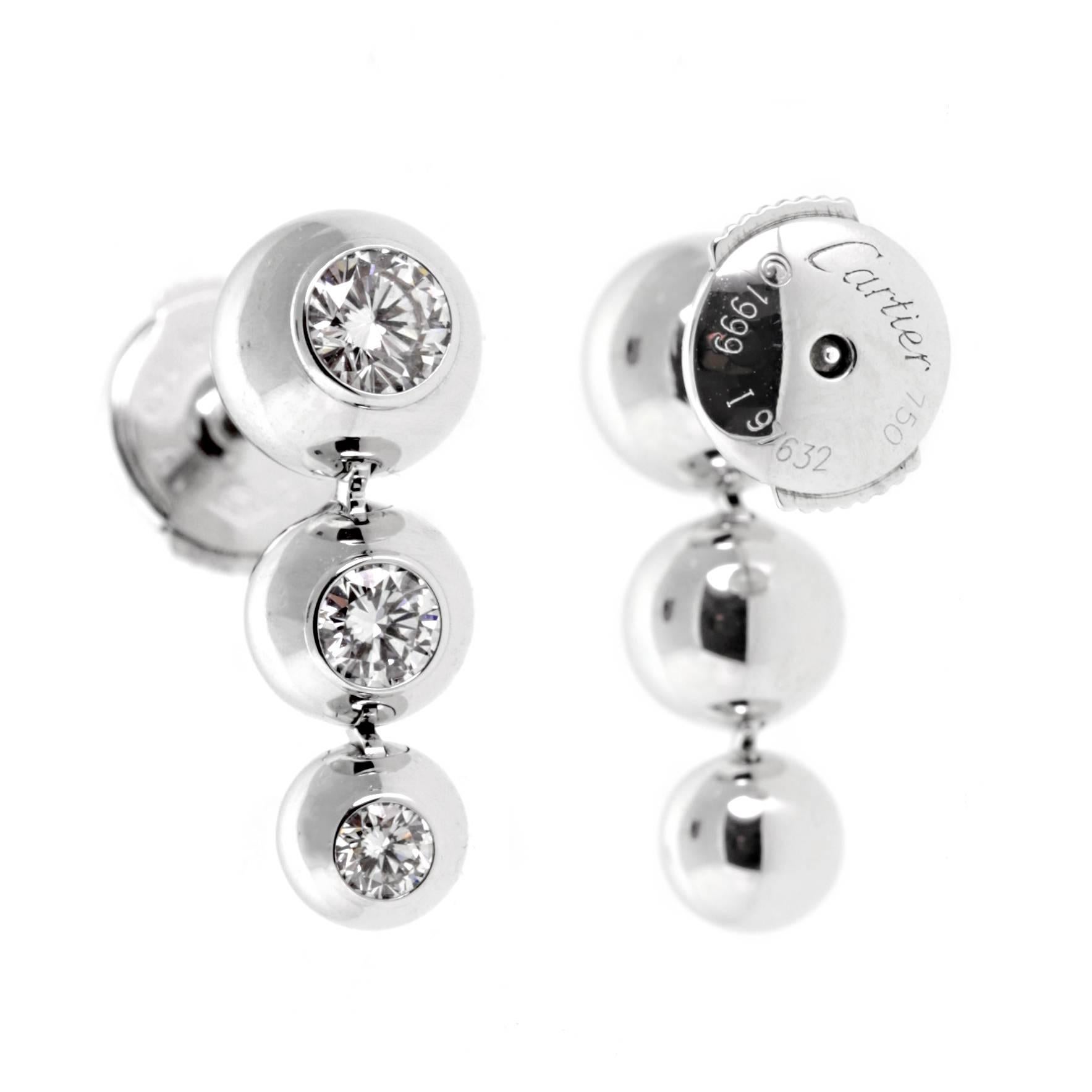 An authentic pair of Cartier diamond earrings each featuring 3 of the finest Cartier round brilliant cut diamonds set in white gold. The earrings have a length of .70"


