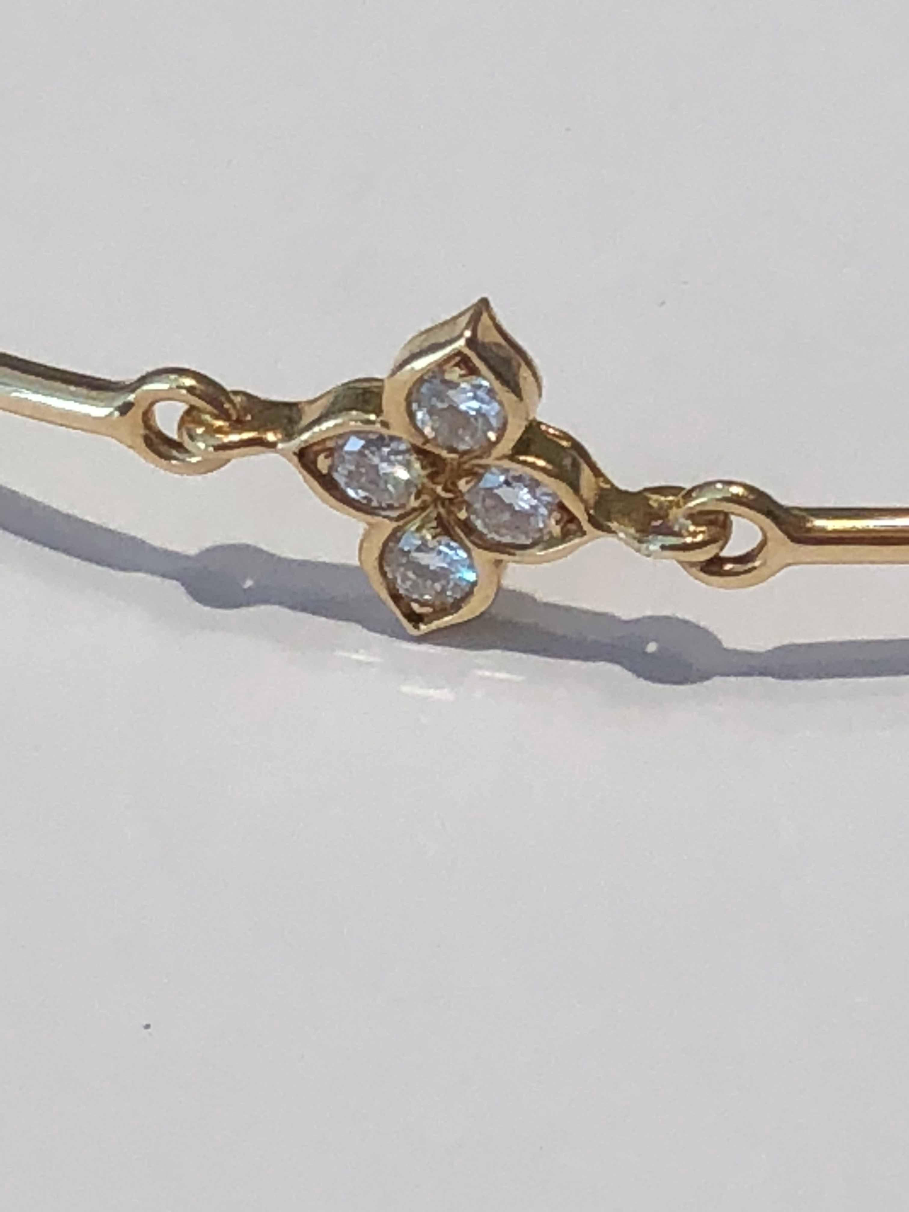 A fabulous Cartier bracelet featuring a flower motif set with 4 round brilliant cut diamonds in 18k yellow gold.