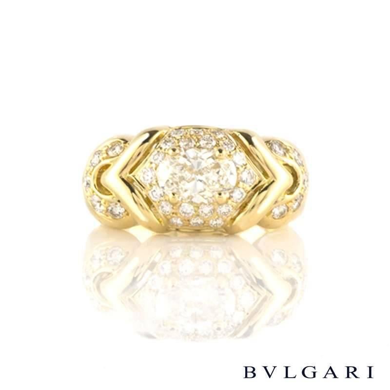 A stunning 18k yellow gold oval diamond dress ring by Bulgari. The ring is set to the centre with a claw set 0.80ct oval brilliant cut diamond, I/J in colour and VS in clarity. The central stone is complemented by a hexagonal border of pave set