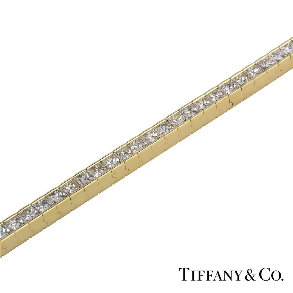 A beautiful 18k yellow gold diamond line bracelet by Tiffany & Co. The bracelet features 60 princess cut diamonds totalling approximately 15.00ct and VS+ in clarity. The bracelet measures approximately 7.25 inches and has a gross weight of
