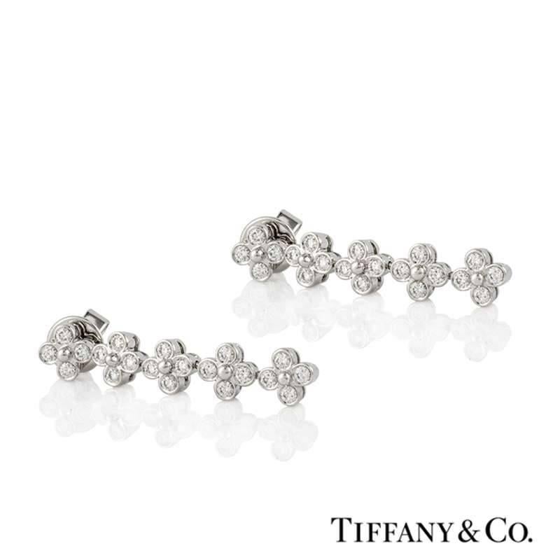 A beautiful pair of diamond set drop earrings in platinum by Tiffany & Co. Each earring is composed of 5 suspending flower motifs, each made up of 4 round brilliant cut diamonds. The total diamond weight is approximately 1.20ct, colour G+ and