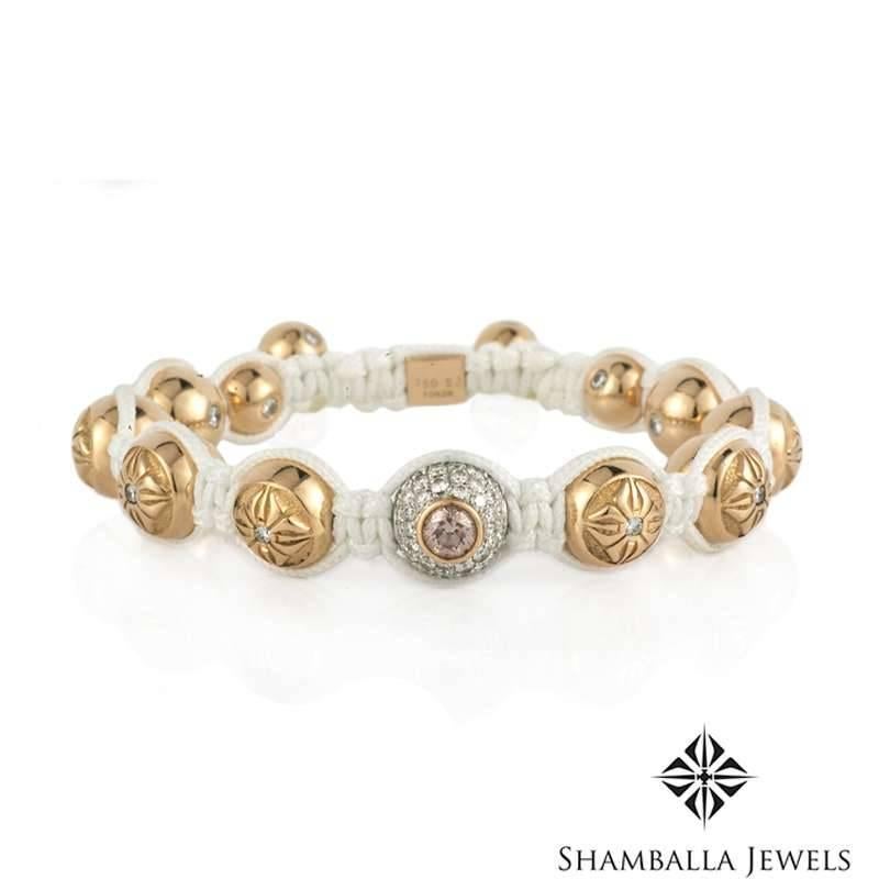 An 18k rose gold diamond set bracelet by Shamballa Jewels. The bracelet is set to the centre with a single pave set diamond ball rondel totalling 1.75ct, featuring a single round brilliant cut pink diamond totalling approximately 0.40ct, dispersing
