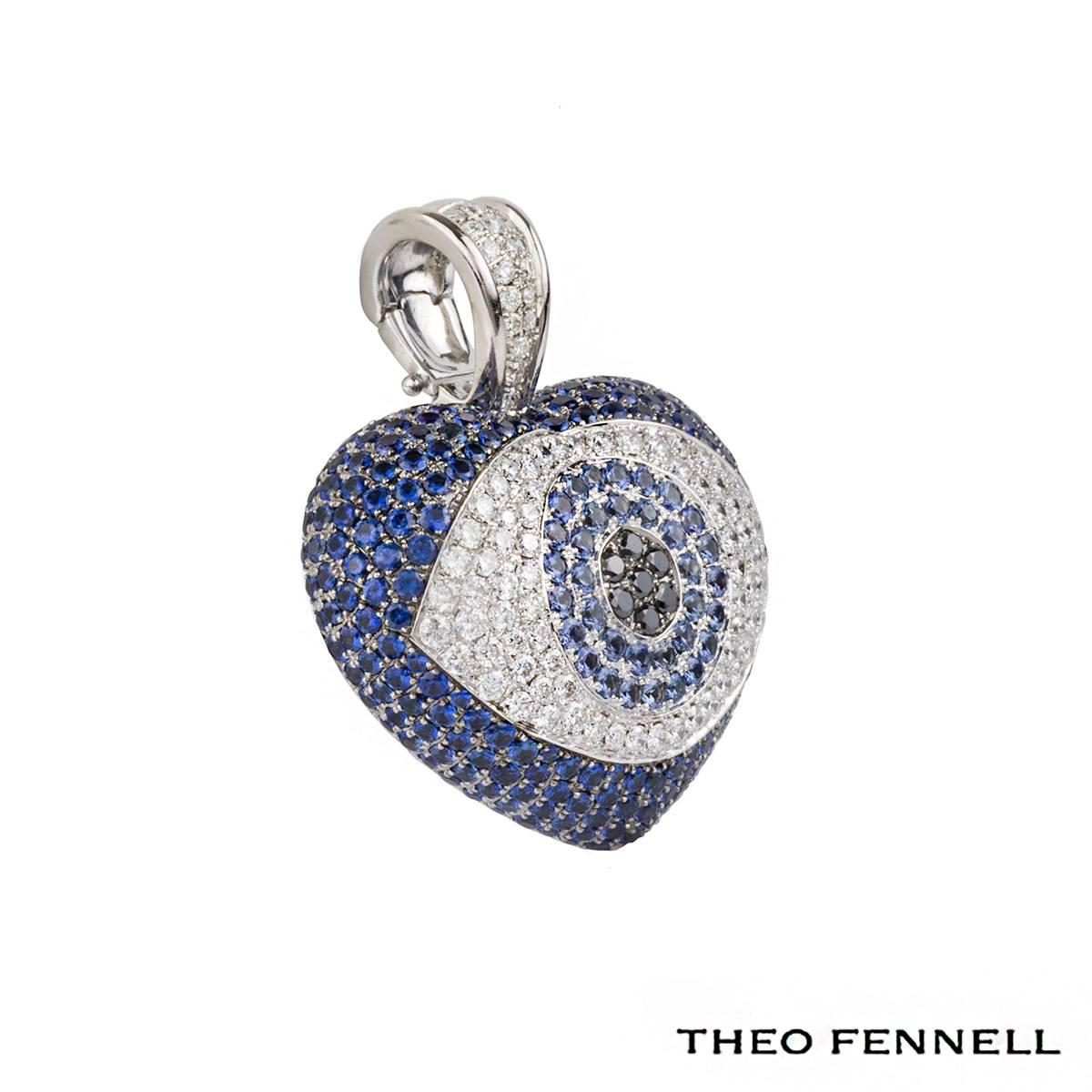 An incredible 18k white gold sapphire and diamond heart pendant from the Evil Eye collection by Theo Fennell. The pendant is set in a heart shaped motif and comprises of an eye motif to the centre. The eye is set with pave set black diamonds which