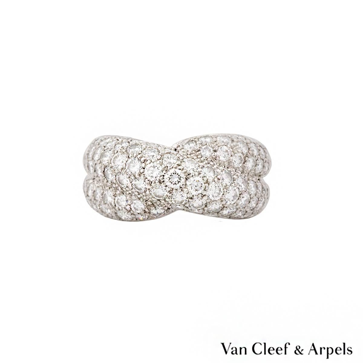 An 18k white gold diamond set dress ring by Van Cleef & Arpels. The ring is composed of two cross over intersections, each pave set with round brilliant cut diamonds totalling approximately 1.20ct, predominantly F/G colour and VS2 in clarity.