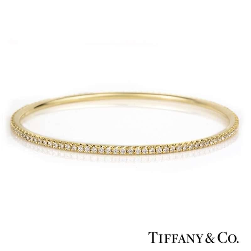 A delightful Metro bangle from Tiffany & Co. in 18k yellow gold. The bangle has 108 round brilliant cut claw set diamonds with a total diamond weight of 1.59ct. The bangle is size medium and has a gross weight of 13.20 grams. 
The bangle comes
