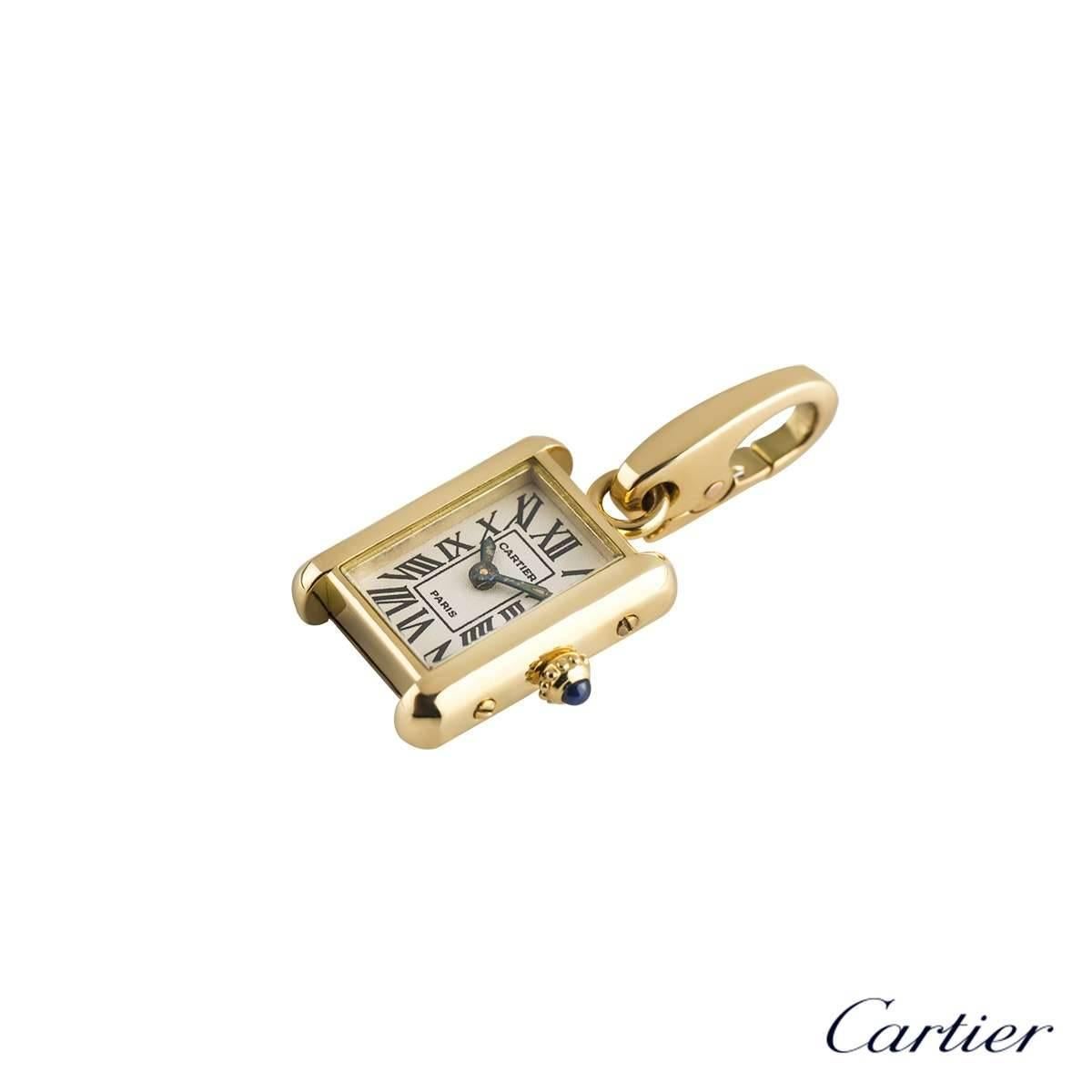 An 18k yellow gold Tank charm by Cartier. The charm is designed as a Tank watch face, with a cream dial and roman numerals, complimented with a single cabochon sapphire for the winder. The charm measures 1.2cm X 2.3cm and has a lobster clasp with a