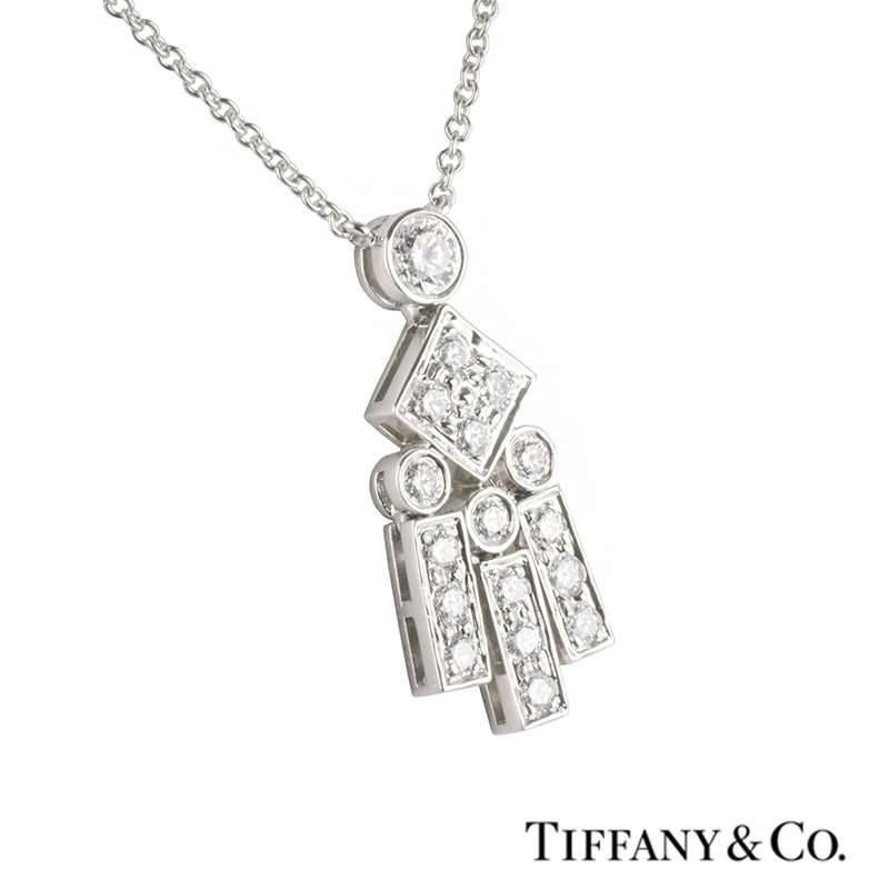 A diamond set pendant in platinum by Tiffany & Co's Legacy Collection. The pendant is set to the top with a single round brilliant cut diamond leading on to a freely moving geometric design, made up of a kite motif and vertical strands, each