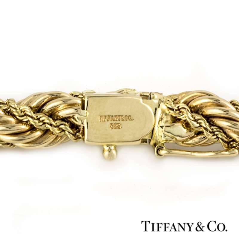 A 14k yellow gold rope design bracelet by Tiffany and Co. The bracelet is made up of a rope design, complemented by a finer twist rope detail running throughout the centre of the bracelet, complete with a descrete tongue and groove clasp and a