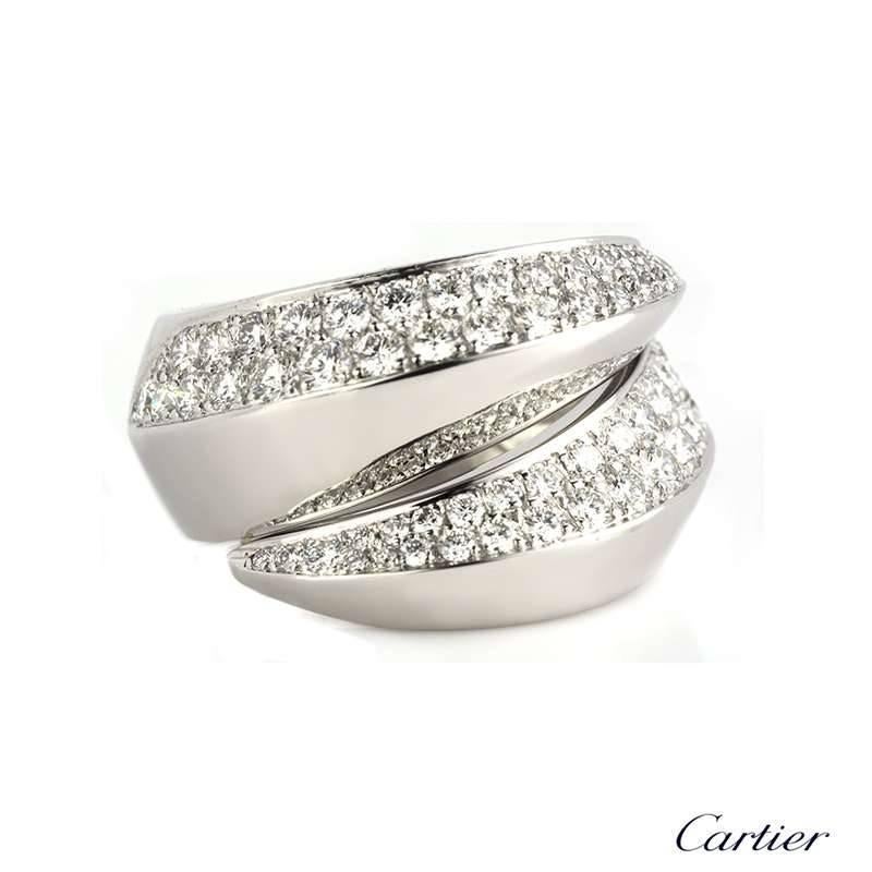 An 18k white gold diamond set Cartier Demi-Parure ring. The spiral design ring is partially set in two intersections with round brilliant cut pave diamonds totalling approximately 1.60ct, predominantly G in colour and VS clarity. The ring is 1.4cm