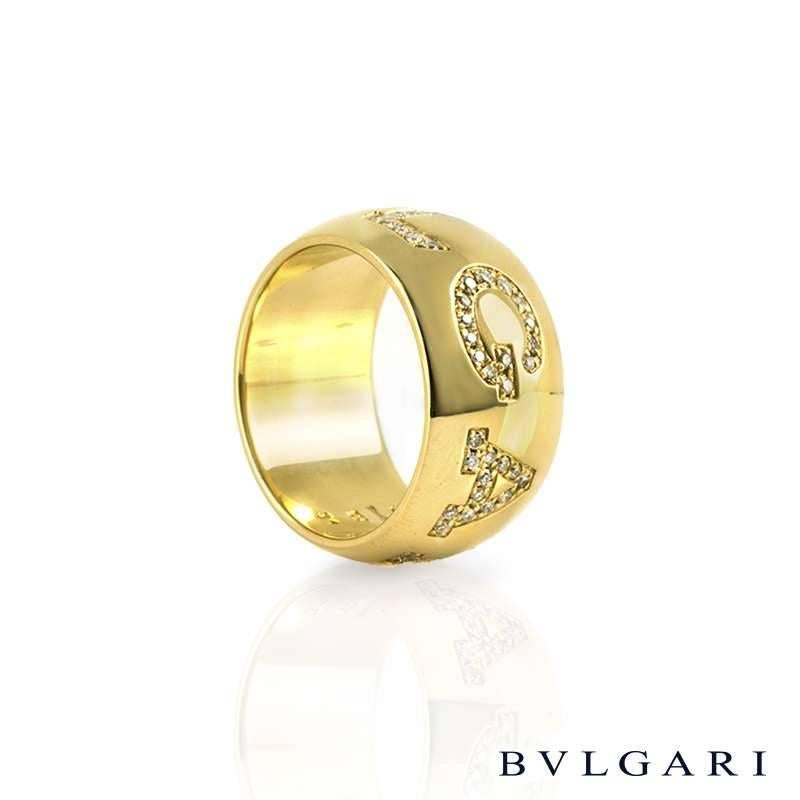 An iconic 18k yellow gold Bvlgari monologo diamond ring. The 'BVLGARI' signature is boldly set with pave diamonds. The diamonds total approximately 0.50ct, G+ colour and VS+ clarity. The ring measures 10mm in width and is a US size 5.75. The gross