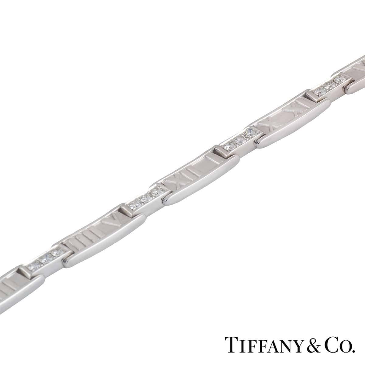 An 18k white gold and diamond Tiffany & Co necklace from the Atlas collection. The necklace features the atlas motif alternating with plain white gold bars half way down, the other half has 3 round brilliant cut diamonds in a pave setting with an