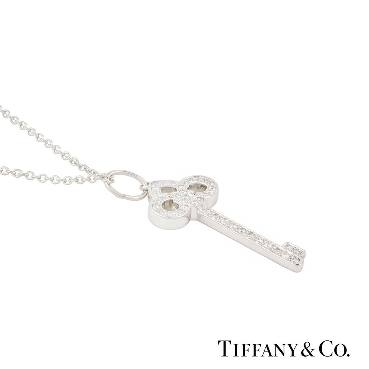 An elegant diamond set pendant from the Tiffany & Co Keys collection in platinum. The key shape pedant features the Fleur De Lis motif set to the top and is pave set with round brilliant cut diamonds totalling approximately 0.12ct. The pendant