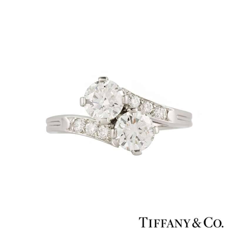 A diamond set ring in platinum by Tiffany & Co. The crossover design ring is set to the centre with two round brilliant cut diamonds in a four claw compass setting, totalling approximately 1.00ct, H/I in colour and VS in clarity. Accentuating