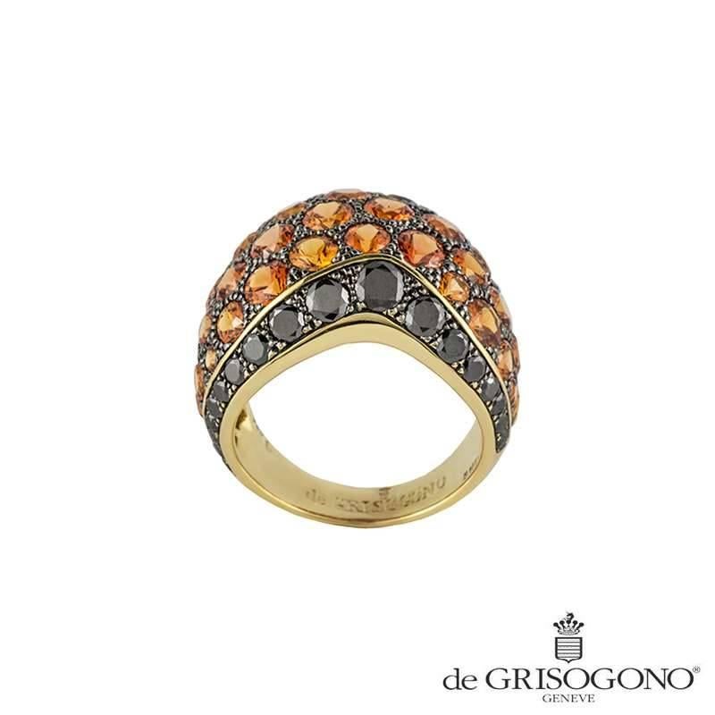 A contemporary 18k yellow gold sapphire and diamond dress ring. The bombe style ring is set throughout the centre with 42 orange round sapphires totalling 10.51ct set within a milligrain setting. The sapphires graduate in sizes and disperse various