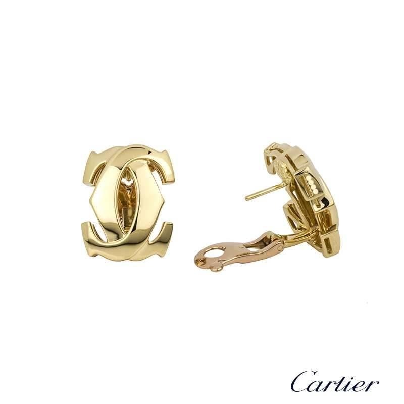 A pair of 18k yellow gold earrings from the Cartier C de Cartier collection. Each earring is composed of the iconic C de Cartier, interweaving C motifs finished with a post and clip fitting. The motifs measure approximately 2cm X 1.5cm and have a