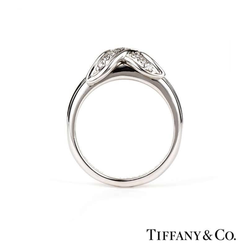 An 18k white gold diamond set ring from the Tiffany & Co. Schlumberger collection. The ring is set to the centre with the iconic Schlumberger cross motif, of which is pave set with 15 round brilliant cut diamonds set to a 5mm tapered mount. The