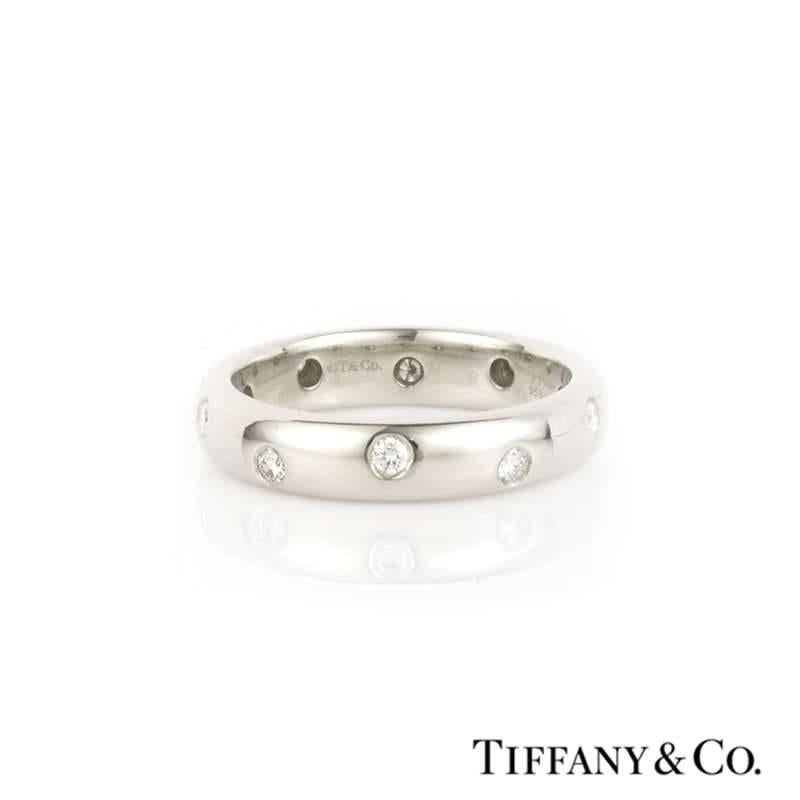 A platinum and diamond ring from the Tiffany & Co. Etoile collection. The band is court fit and has 10 round brilliant bezel set diamonds spread around the outer edge. The diamonds have a total diamond weight of 0.23ct, the colour is F/G and the