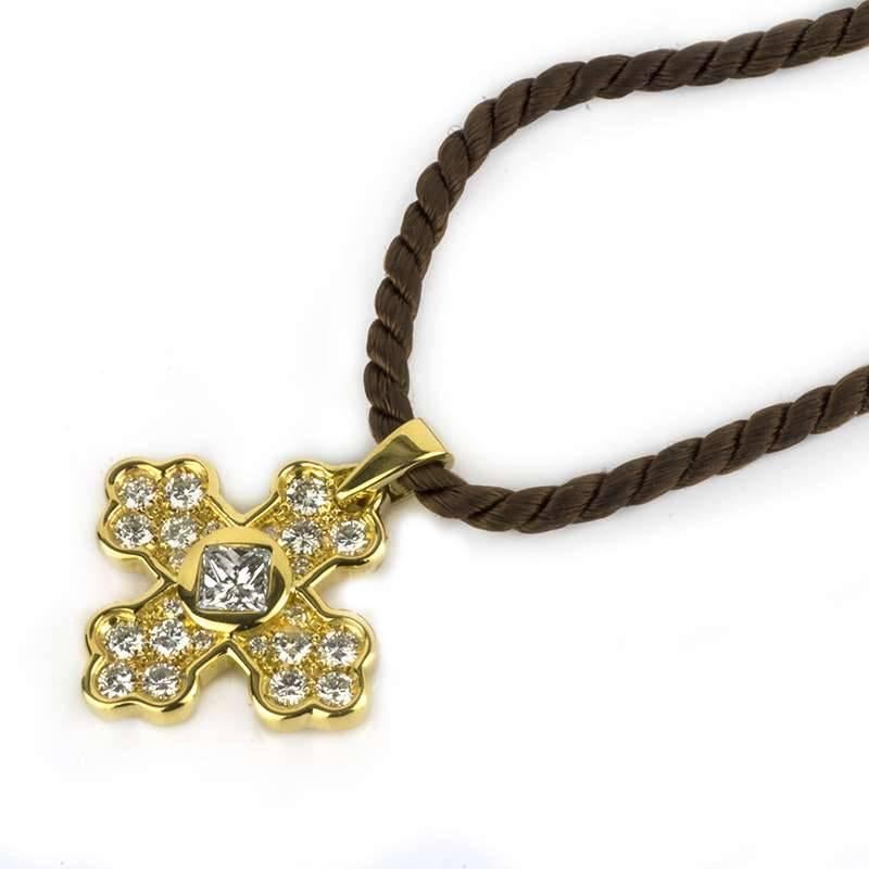 An 18k yellow gold diamond set cross pendant by Marina B. The cross is of celtic design consisting of pave set round brilliant cut diamonds set to each 4 quadrants, set to the centre with a princess cut diamond weighing approximately 0.35ct. The