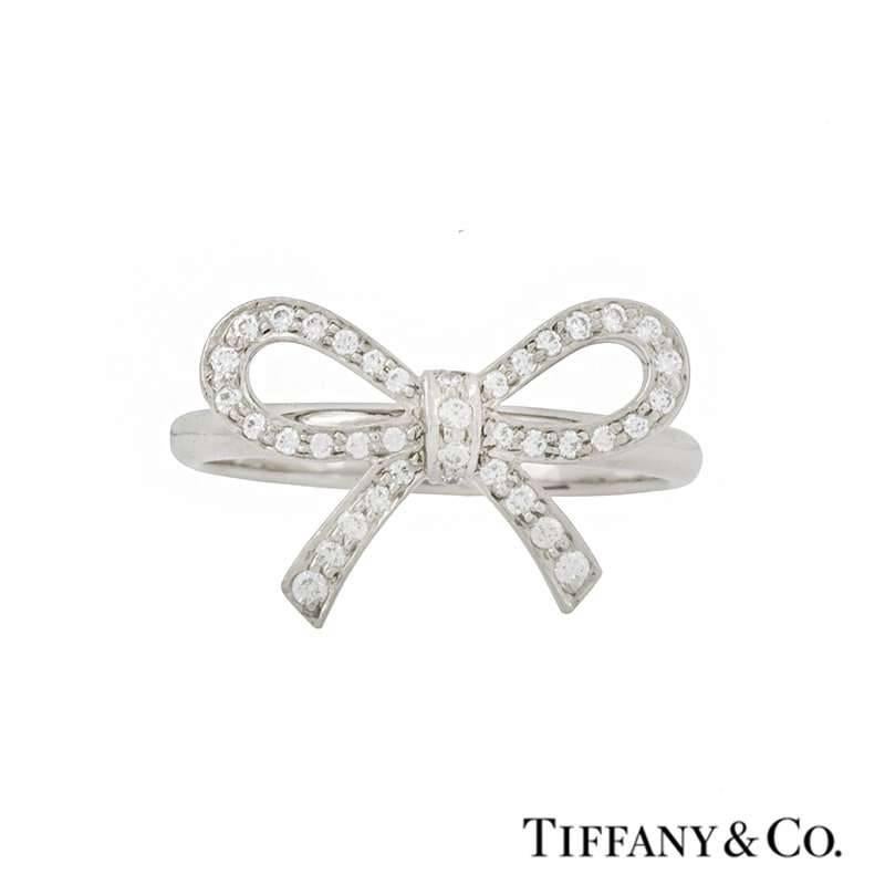 An elegant diamond set ring by Tiffany & Co. The openwork bow design measures 1.7cm X 1.00cm and is pave set with round brilliant cut diamonds totalling approximately 0.20ct, G+ colour and VS+ in clarity. The ring is currently a US size 5 1/4,