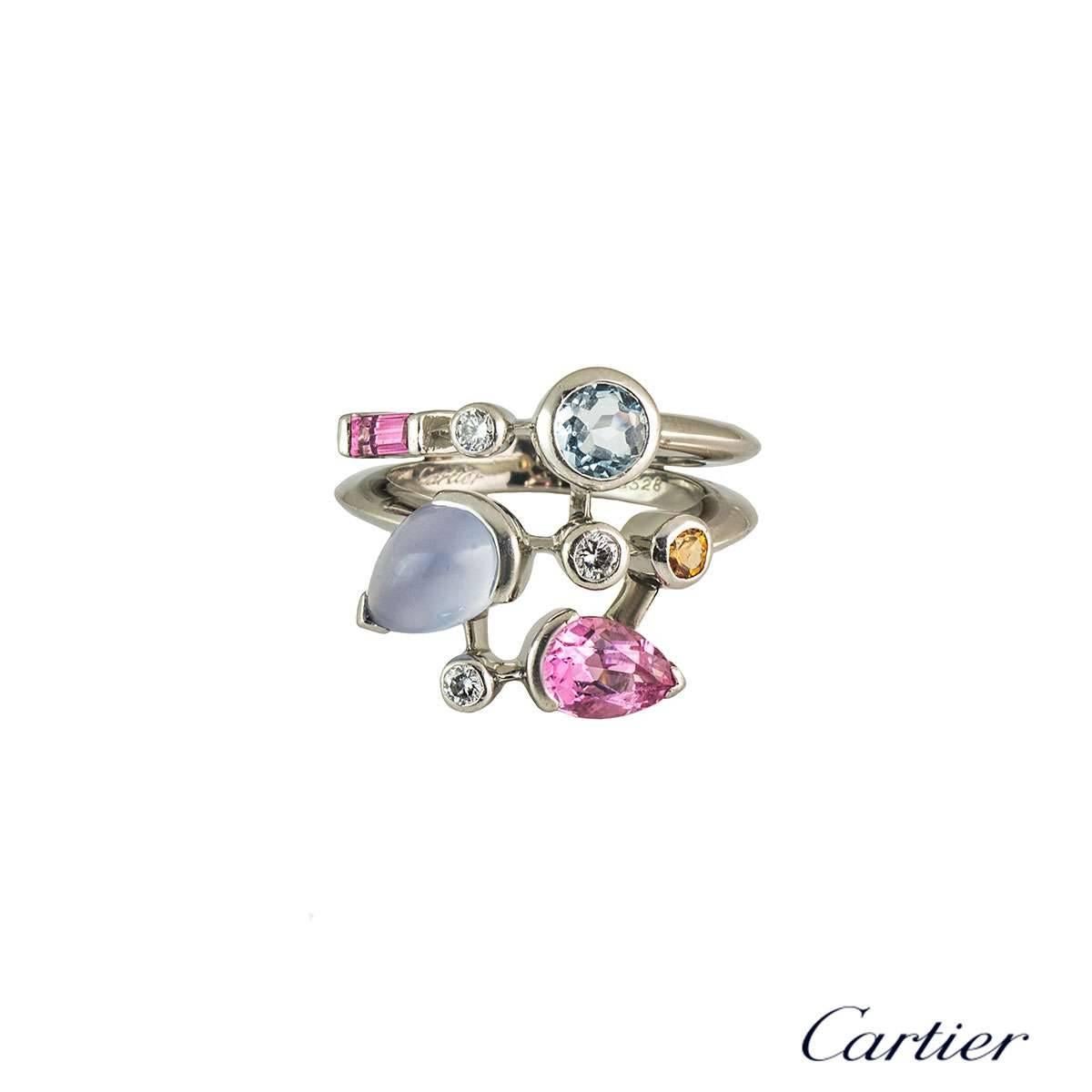 A trendy 18k white gold Cartier diamond and multi-gemstone ring from the Meli Melo collection. The ring comprises of 8 gemstones abstractly placed over 3 rows, consisting of diamonds, aquamarine, chalcedony, garnet and pink tourmaline. There are 3