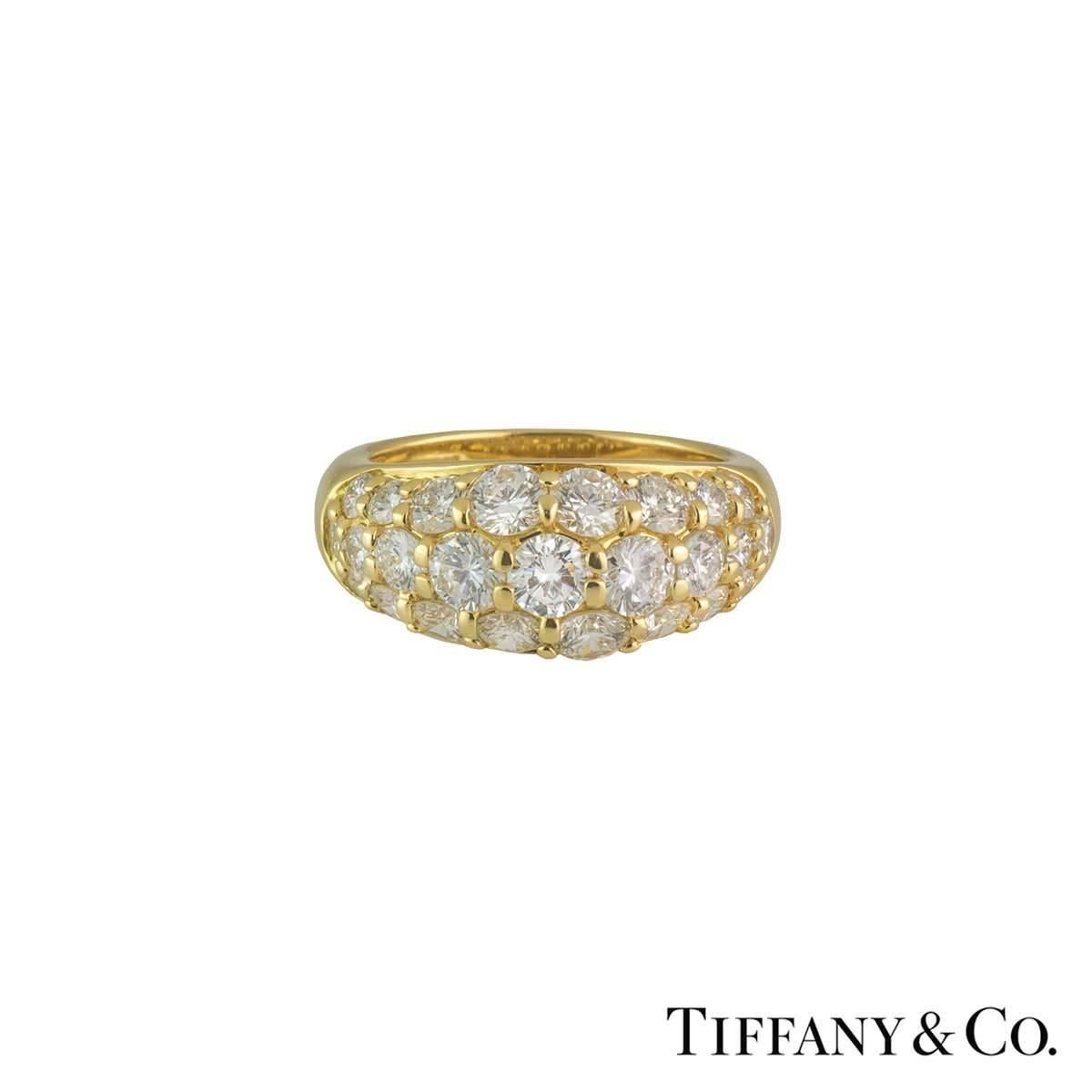 A stunning 18k yellow gold diamond set bombe style half eternity ring by Tiffany & Co. The ring is set to the centre with three rows of graduating round brilliant cut diamonds, each individually claw set, totalling approximately 2.20ct,