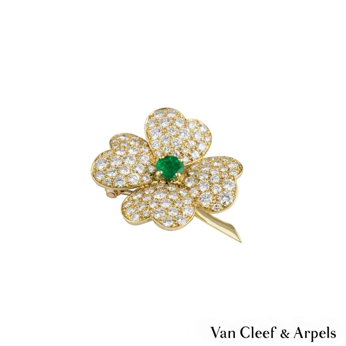 A beautiful 18k yellow gold Van Cleef and Arpels diamond and emerald brooch and earrings from the Cosmos collection. The earrings comprise of a single round cut emerald set to the centre in a 4 claw setting with a total weight of approximately