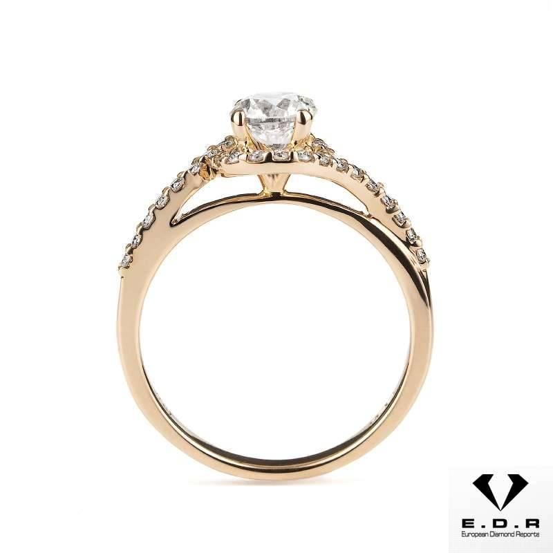 A stunning 18k rose gold diamond ring. The ring is set to the centre with a 0.71ct round brilliant cut diamond, F colour and SI2 clarity, set within a modern diamond set twist mount totalling 0.20ct. The ring is currently a US size 5 1/2, EU size