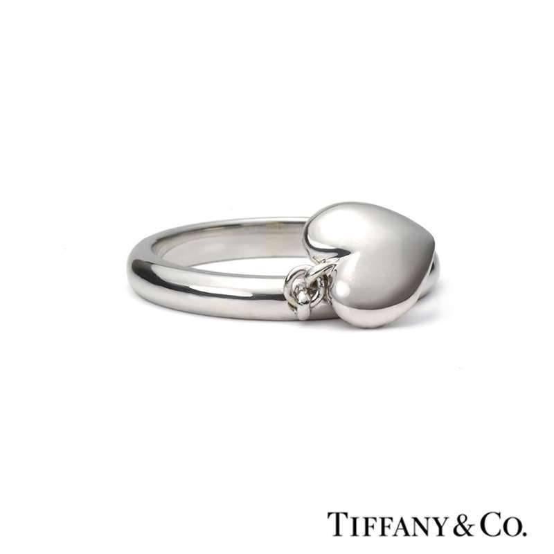 An 18k diamond set ring by Tiffany & Co. The ring features a pave set diamond heart motif suspended from a 2mm polished band. The ring is currently a US 4, EU size 47 and UK size I but can be adjusted for a perfect fit and has a gross weight of 6.90
