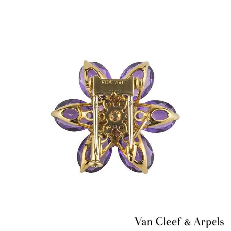 A beautiful pink sapphire and amethyst floral brooch from the Hawaii collection by Van Cleef and Arpels. The brooch is set to the centre with 20 pave set round graduated pink sapphires totalling approximately 1.00ct complemented by 6 pear shape